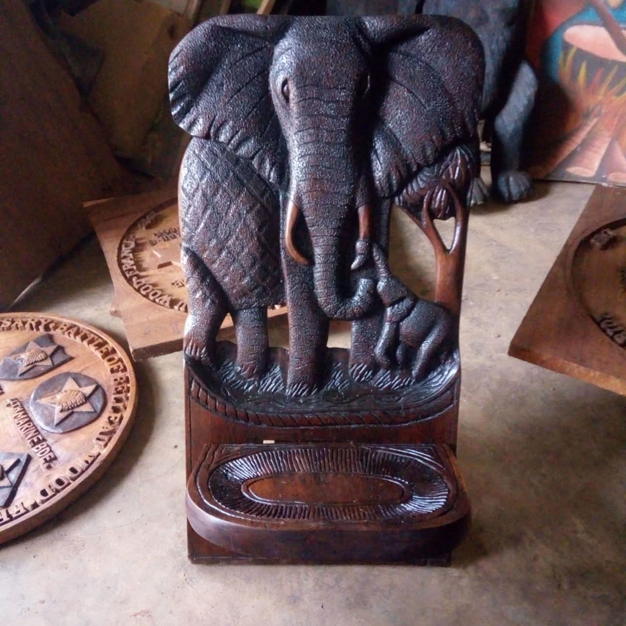Carved wooden piece by Silver showing an elephant with its calf beside a tree