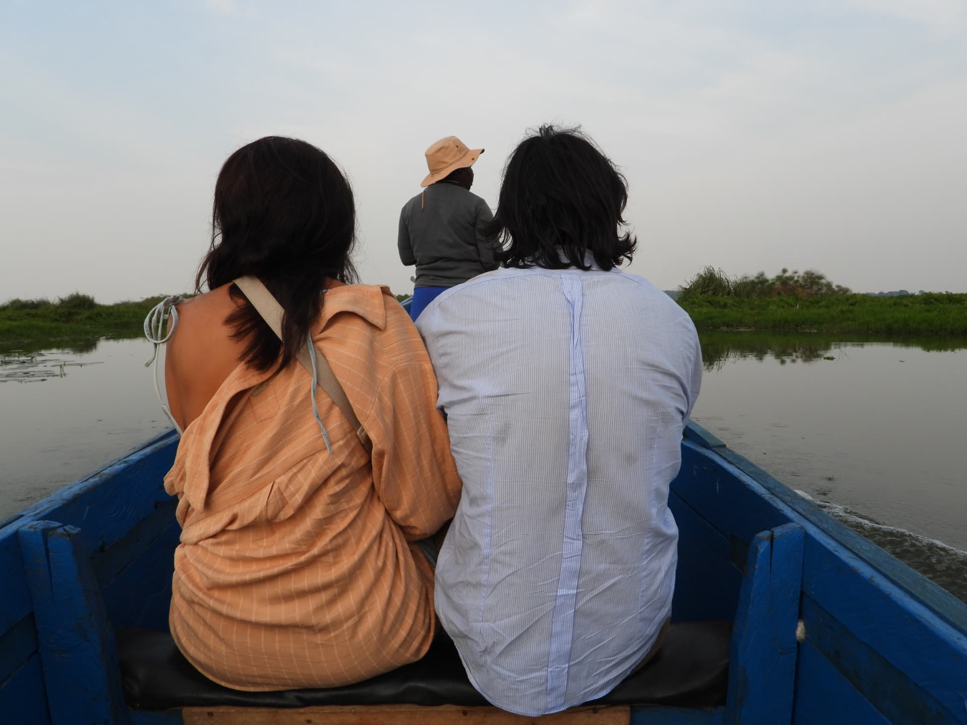 Travellers in a wooden boat heading into the Mabamba wetlands