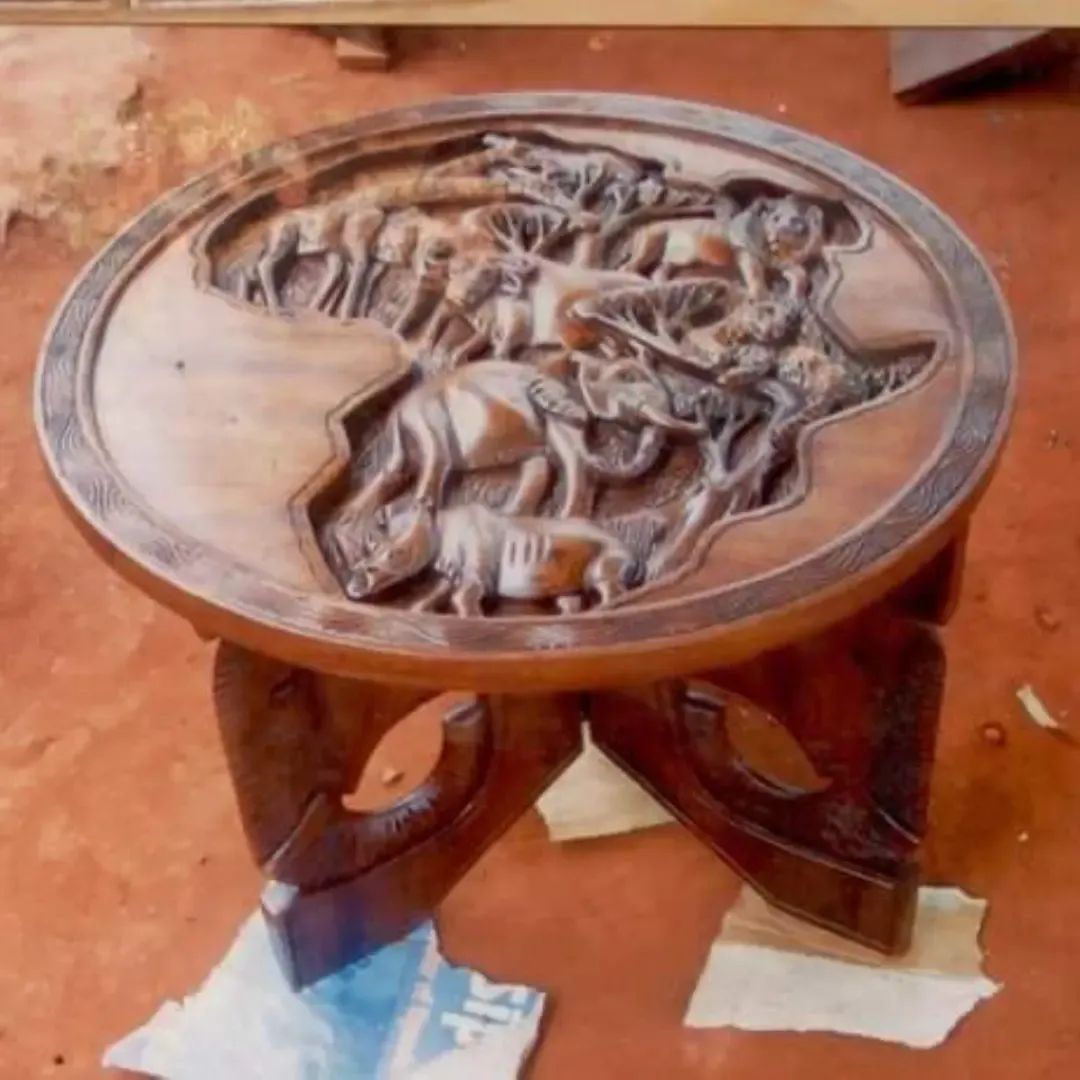Small carved wooden table by Silver with a map of Africa and wildlife scene on top
